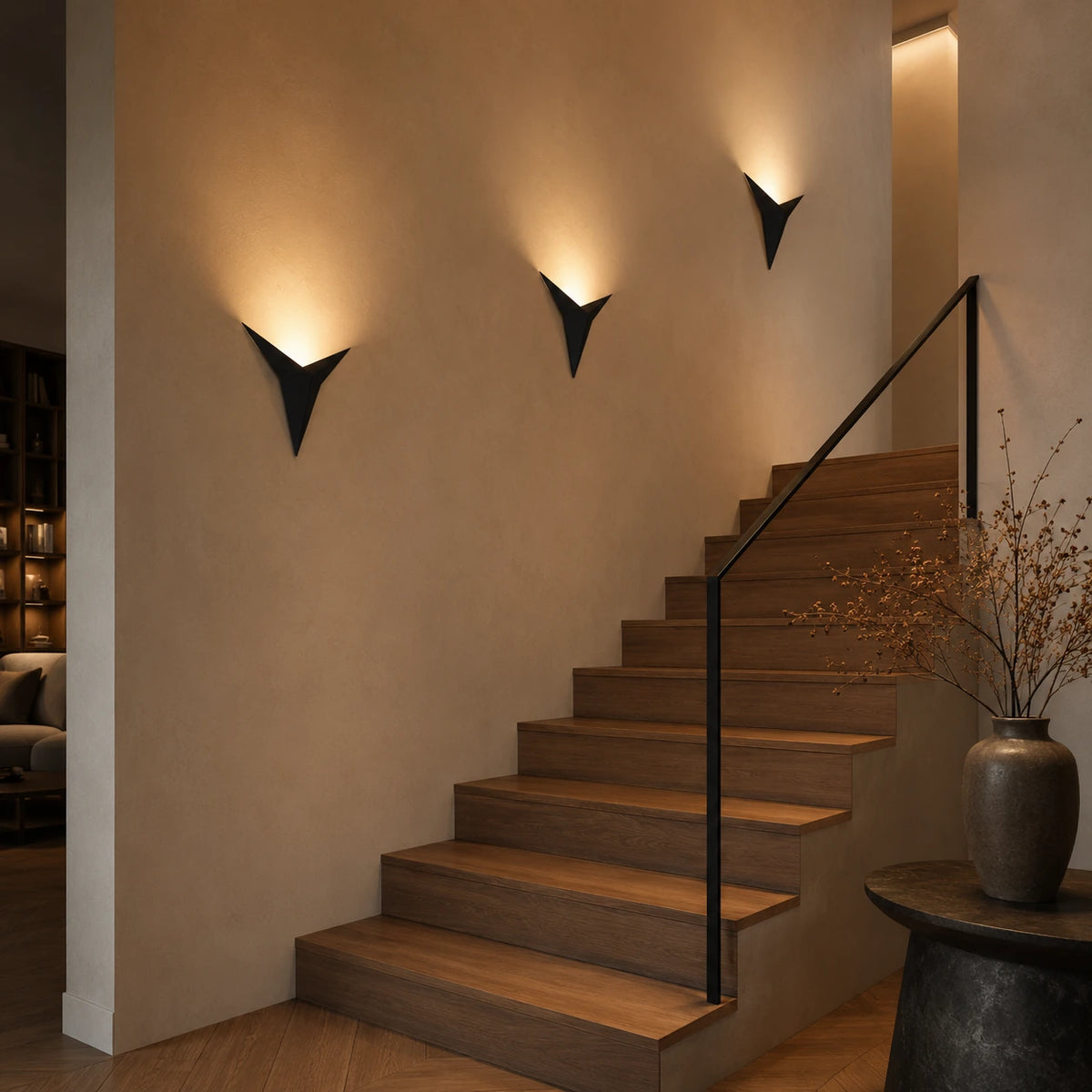 Trois abat-jour muraux origamis noirs disposés le long d'un escalier en bois, ambiance tamisée et graphique