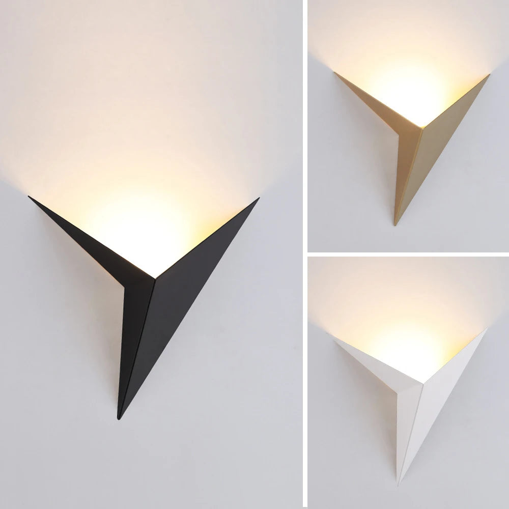 Abat-jour mural triangulaire en métal disponible en 3 coloris — noir, doré et blanc — photographié allumé avec éclairage indirect chaud