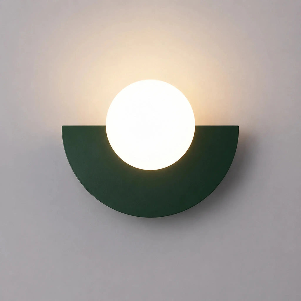 Abat-jour mural vert foncé en demi-lune avec boule en verre dépoli allumée, vue de face sur fond neutre