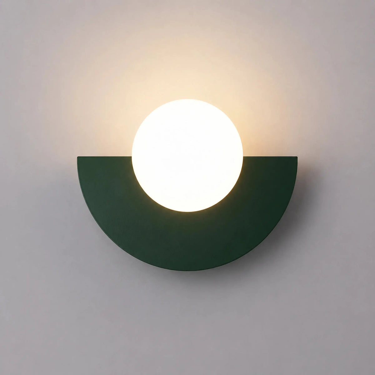 Abat-jour mural vert foncé en demi-lune avec boule en verre dépoli allumée, vue de face sur fond neutre