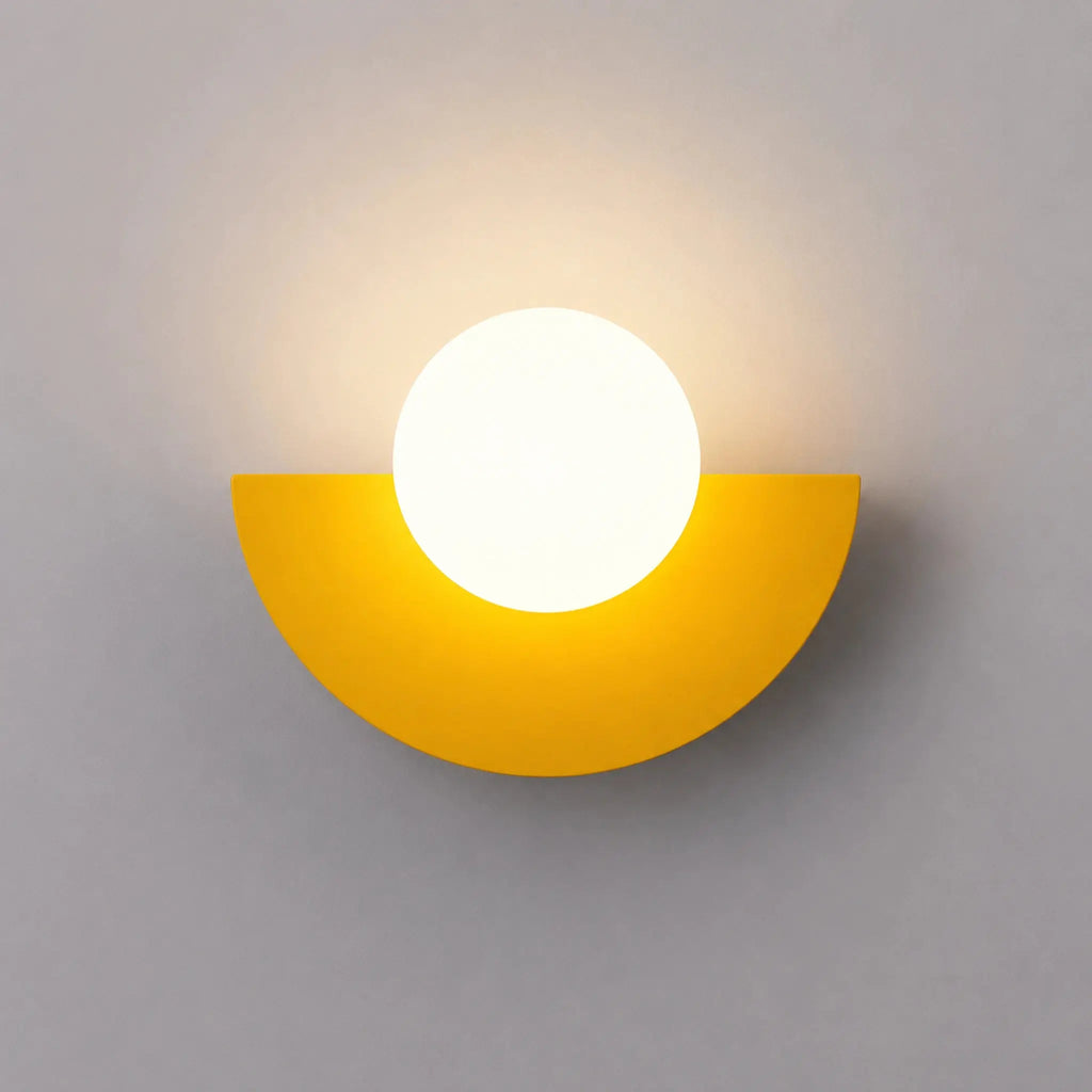 Abat-jour mural jaune en demi-lune avec boule en verre dépoli allumée, vue de face sur fond neutre