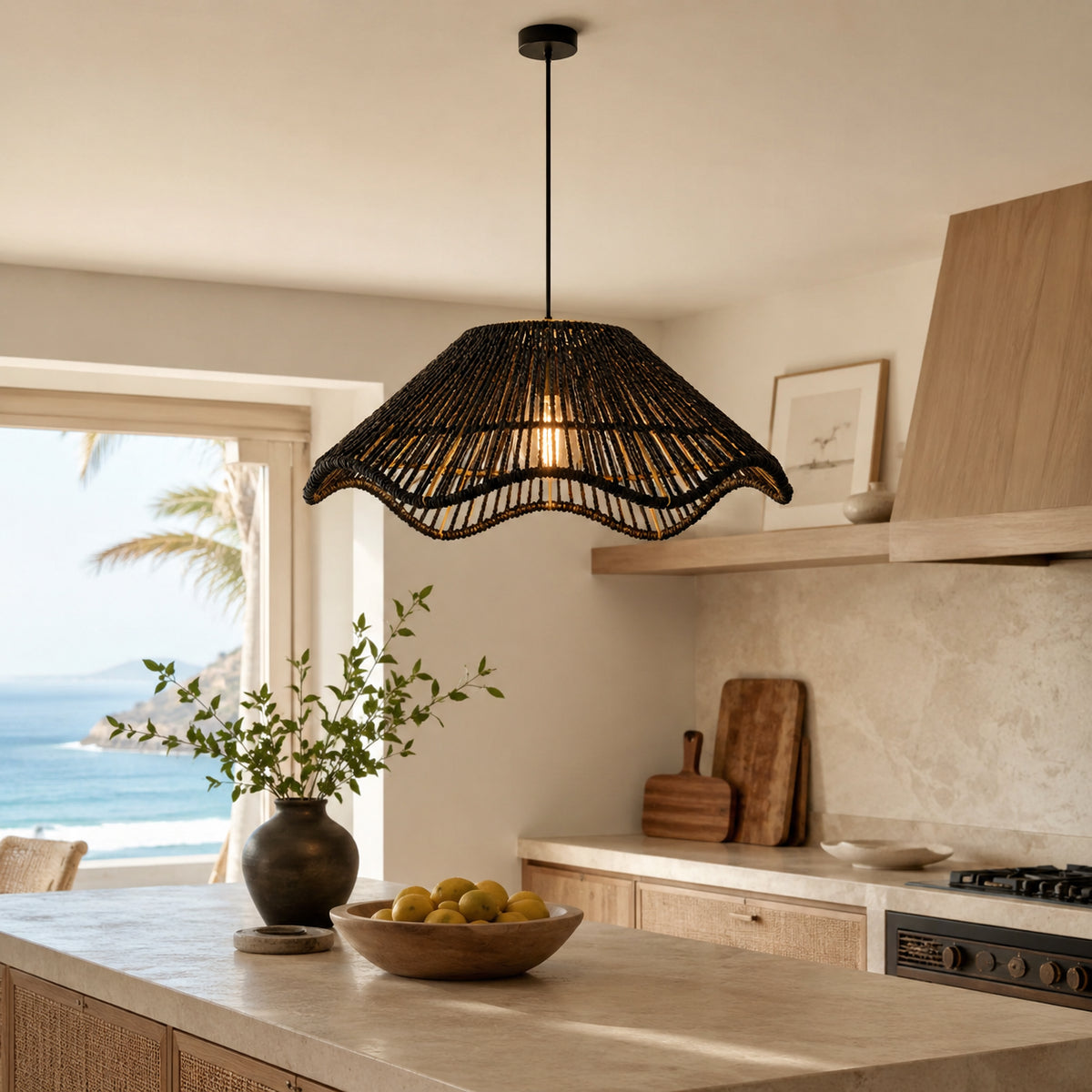 Suspension luminaire noire en fibres tressées au-dessus d’un îlot de cuisine côtière lumineuse.