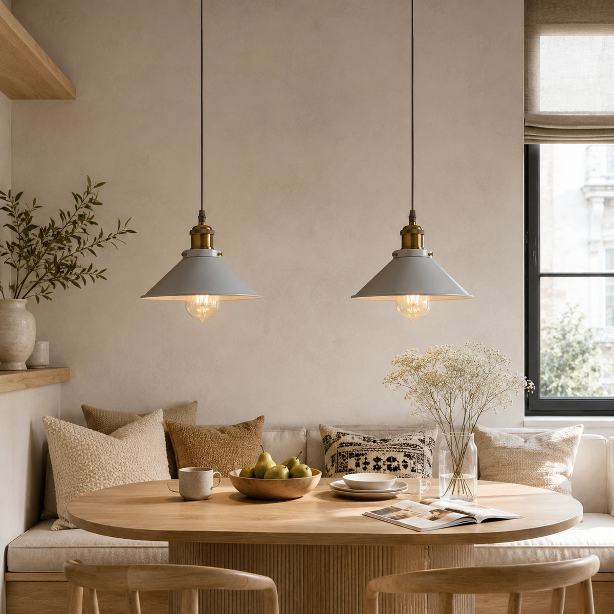 Deux suspensions en métal gris style scandinave au-dessus d'une table ronde et d'une banquette cosy